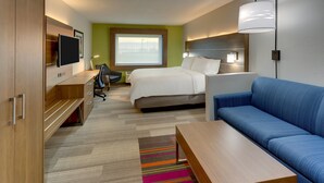Une chambre d’hôtel moderne équipée d’un lit, d’un canapé, d’un bureau et d’une télévision.