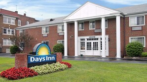 A Days Inn hotel with a brick facade, a large entrance with a double door, and a sign with the hotel name. - Days Inn by Wyndham Cleveland Lakewood (Lakewood)