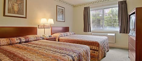 Habitación de hotel con dos camas, televisión, lámpara y ventana con cortinas.