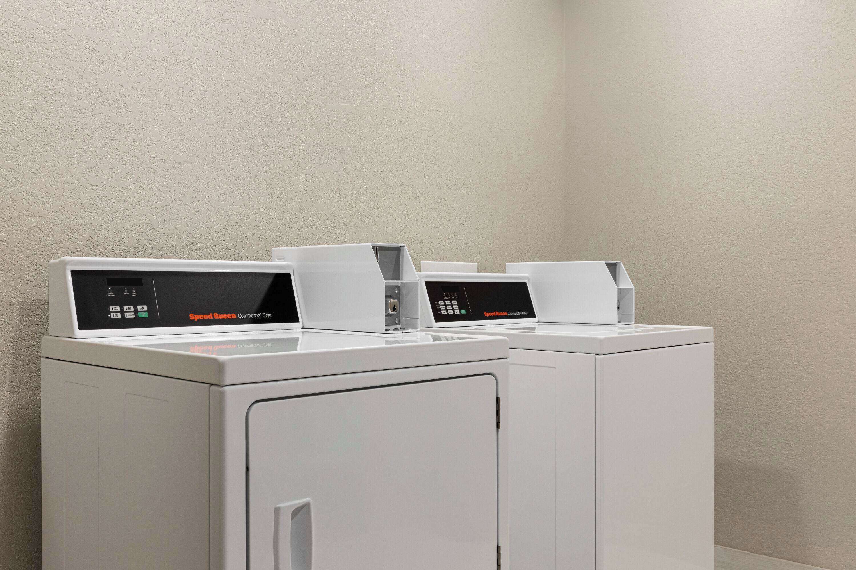 A row of Speed Queen Commercial Dryers in a laundry room.