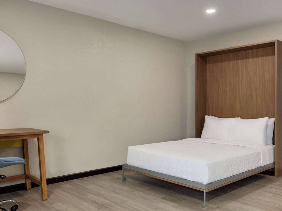Ein Schlafzimmer mit einem Bett, einem Schreibtisch und einem Stuhl.