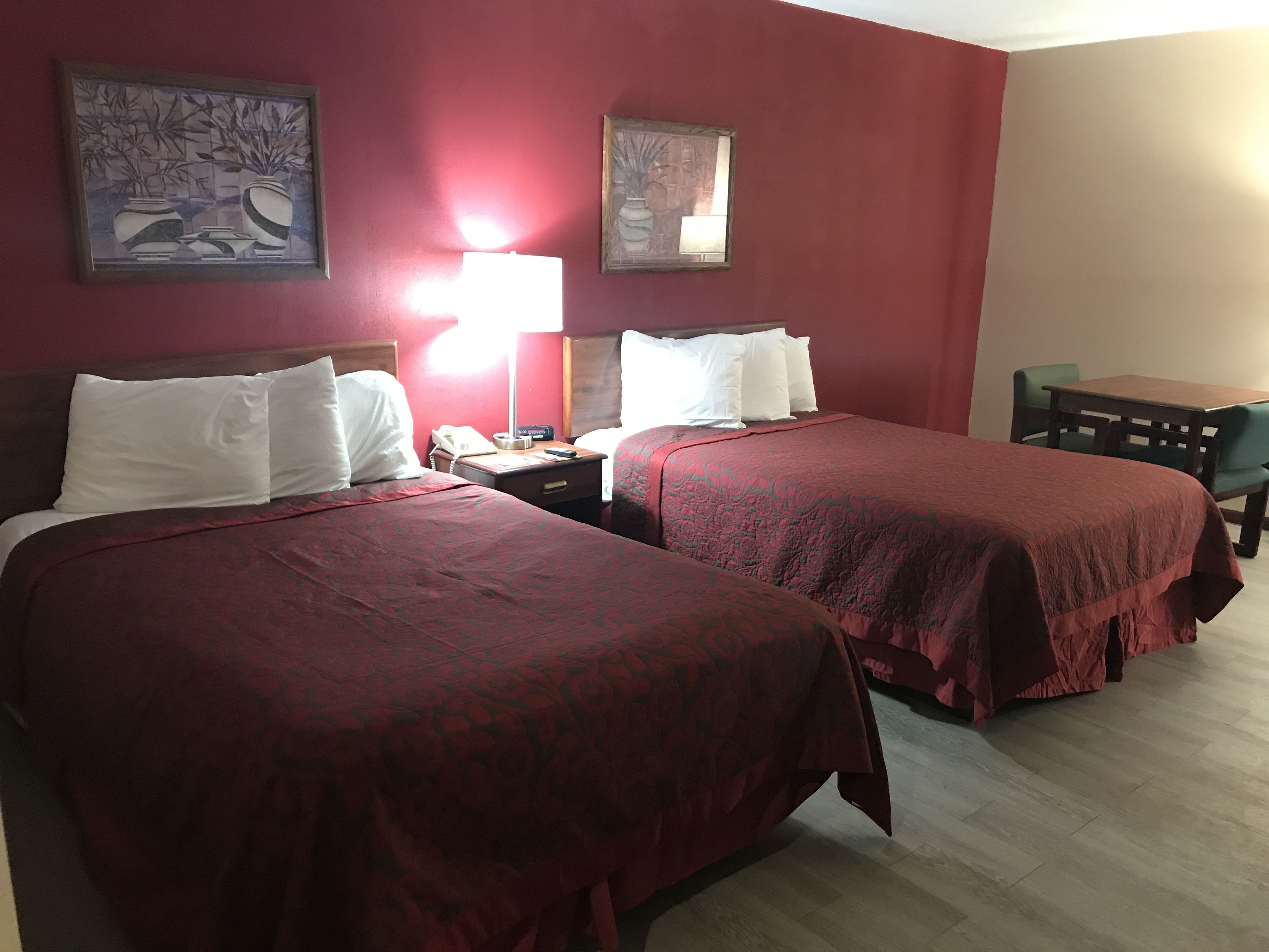 Une chambre d’hôtel avec deux lits, un bureau et une chaise.