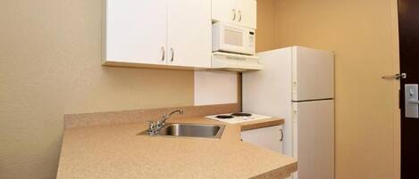 A compact kitchen with a sink, a microwave, and a refrigerator.