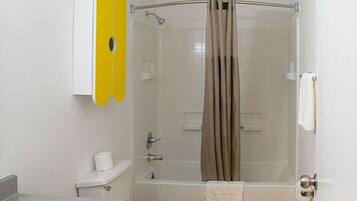 Un baño con inodoro, lavamanos, bañera y cortina de ducha.