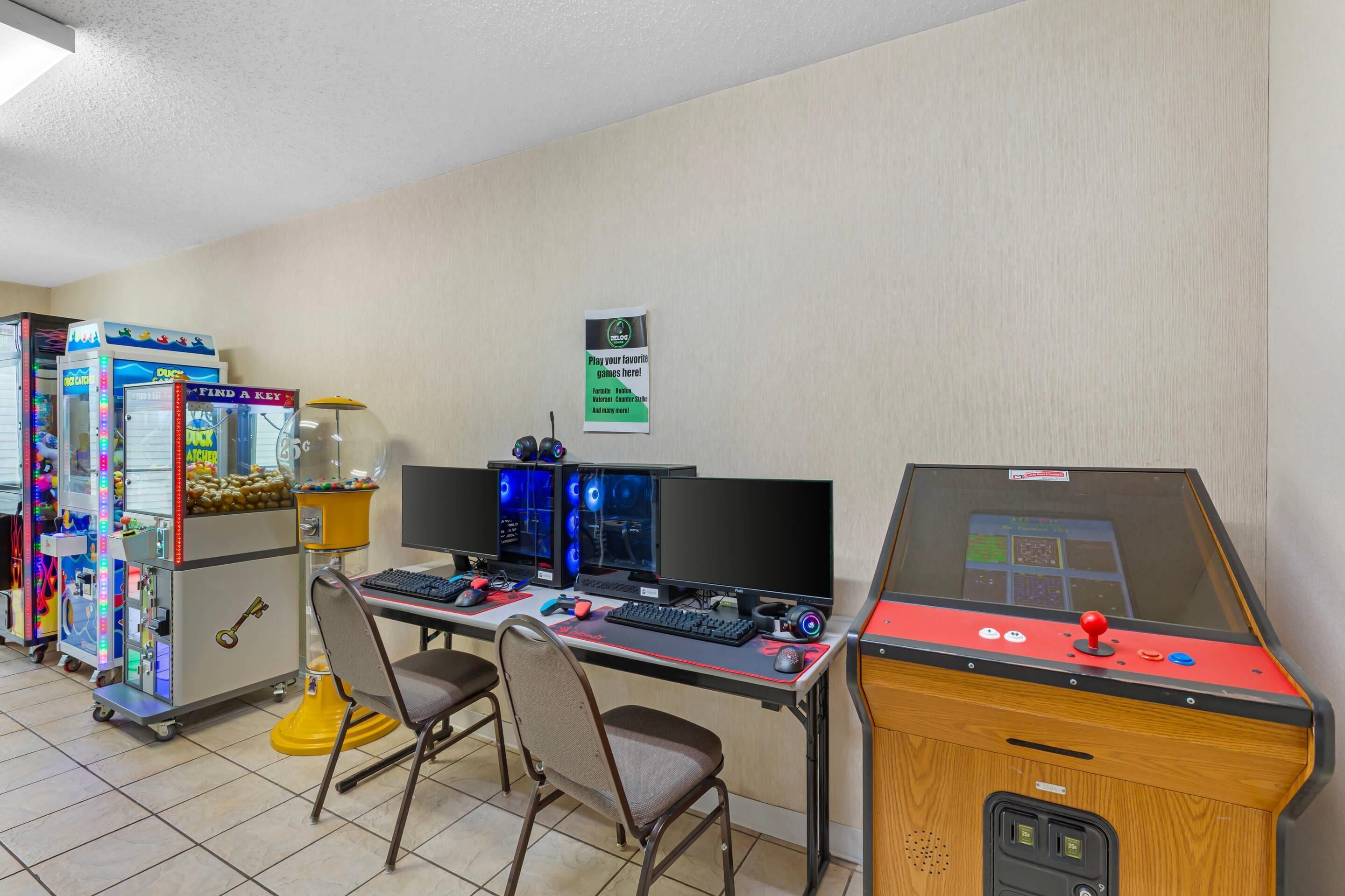 A gaming area with arcade machines, a computer station, and a claw machine.