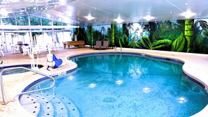An indoor swimming pool with a tropical mural, lounge chairs, and a seating area. - Quality Inn & Suites Bellville - Mansfield (Bellville)