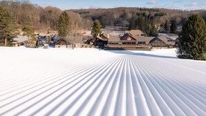 A snow-covered ski resort with lodge buildings, a parking area, and a forested backdrop. - Quality Inn & Suites Bellville - Mansfield (Bellville)