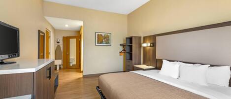 A hotel room with a bed, a TV, a desk, and a wardrobe.