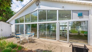 A modern building with large glass windows, a patio with outdoor seating, and a metal signpost. - Quality Inn & Suites Bellville - Mansfield (Bellville)