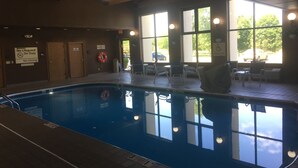 An indoor swimming pool with clear water, surrounded by windows and chairs. - Hampton Inn & Suites Chillicothe (Chillicothe)