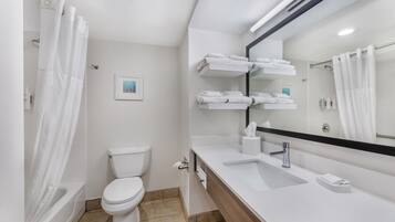 A modern bathroom with a toilet, sink, and mirror.