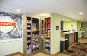 A snack and sundries section with a variety of packaged goods and a large wall mural. - Hampton Inn Wooster (Wooster)