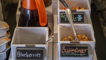 A food display with containers labeled "Blueberries" and "ButteFinger."