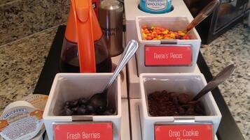 Een ontbijtbuffet met bakken met verse bessen, stukjes Oreo-koekjes en andere lekkernijen.