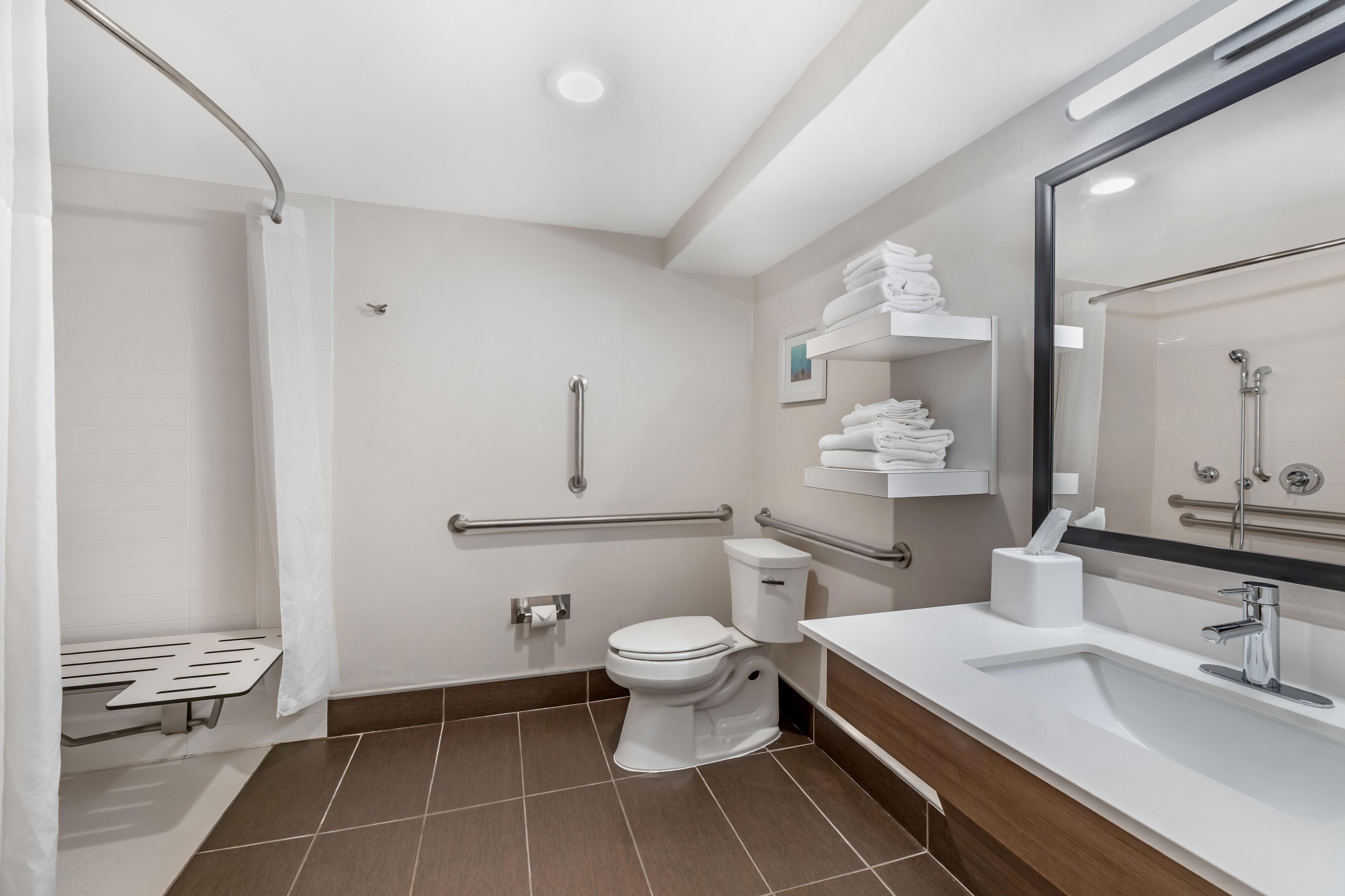 A modern bathroom with a shower, toilet, and sink.