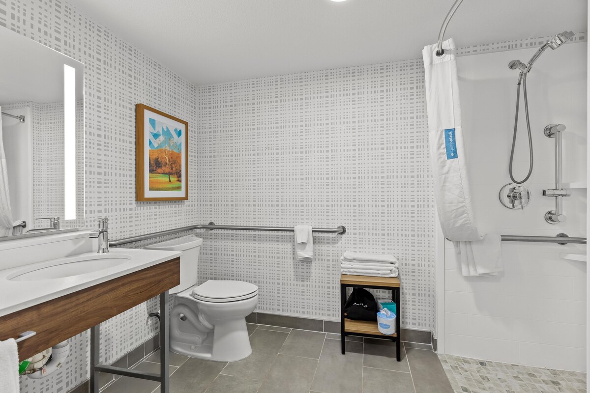 A modern bathroom with a toilet, sink, and shower.