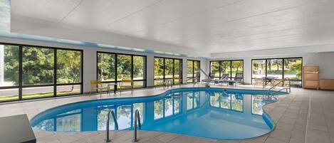 A large indoor swimming pool with clear views of the outdoors through large windows.