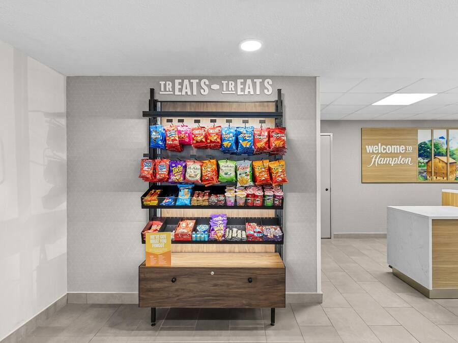 A snack display in a hotel lobby with a sign reading 'LEATS-TREATS' above it.