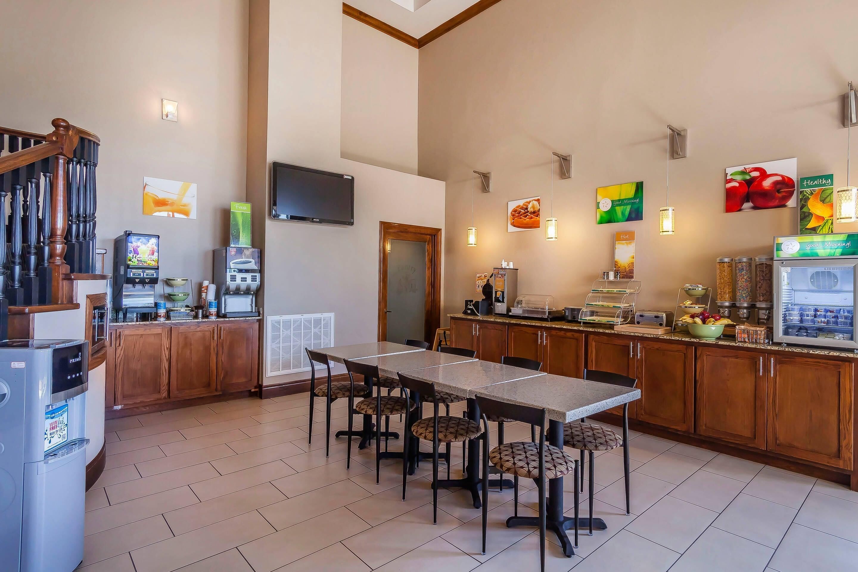 A modern kitchen with a dining area, wooden cabinets, and a built-in refrigerator.