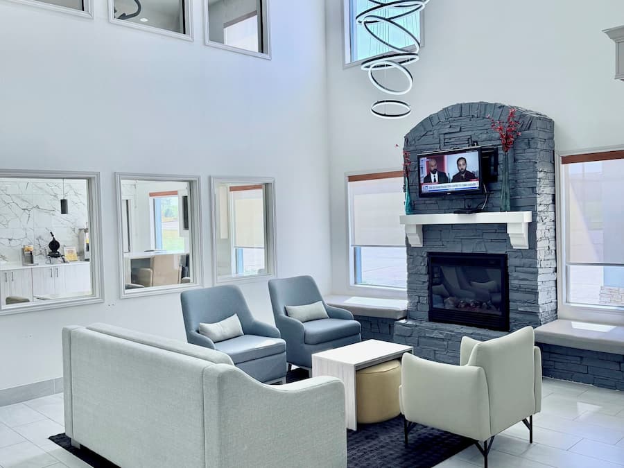 A spacious living room with a fireplace, comfortable seating, and large windows.