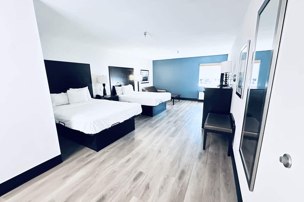 Una habitación de hotel moderna con dos camas, un escritorio y una silla.