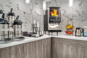 A modern kitchen with a built-in coffee machine, a fruit juice dispenser, and a kettle. - Baymont by Wyndham Ardmore I-35 (Ardmore)