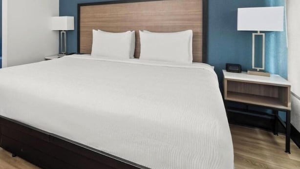 A hotel room with a large bed, two bedside tables, and a nightstand. - Baymont by Wyndham Ardmore I-35 (Ardmore)