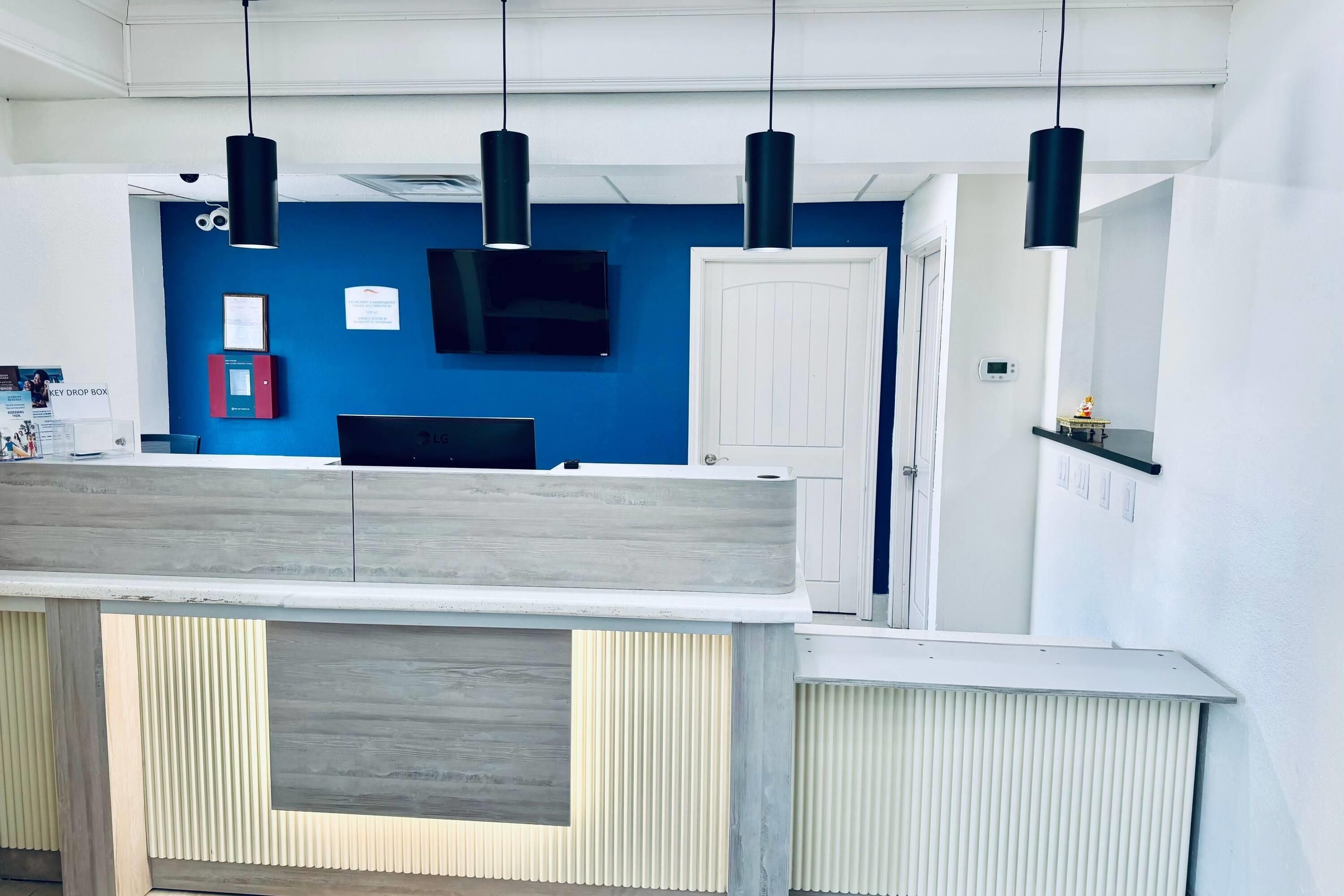 Een modern interieur met een blauwe accentmuur, een flatscreen televisie en hanglampen.