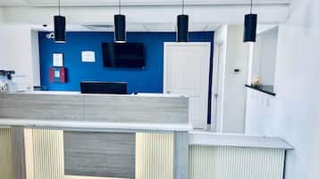 Een modern interieur met een blauwe accentmuur, een flatscreen televisie en hanglampen.