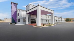 Un bâtiment moderne doté d’une entrée abritée et d’un parking.