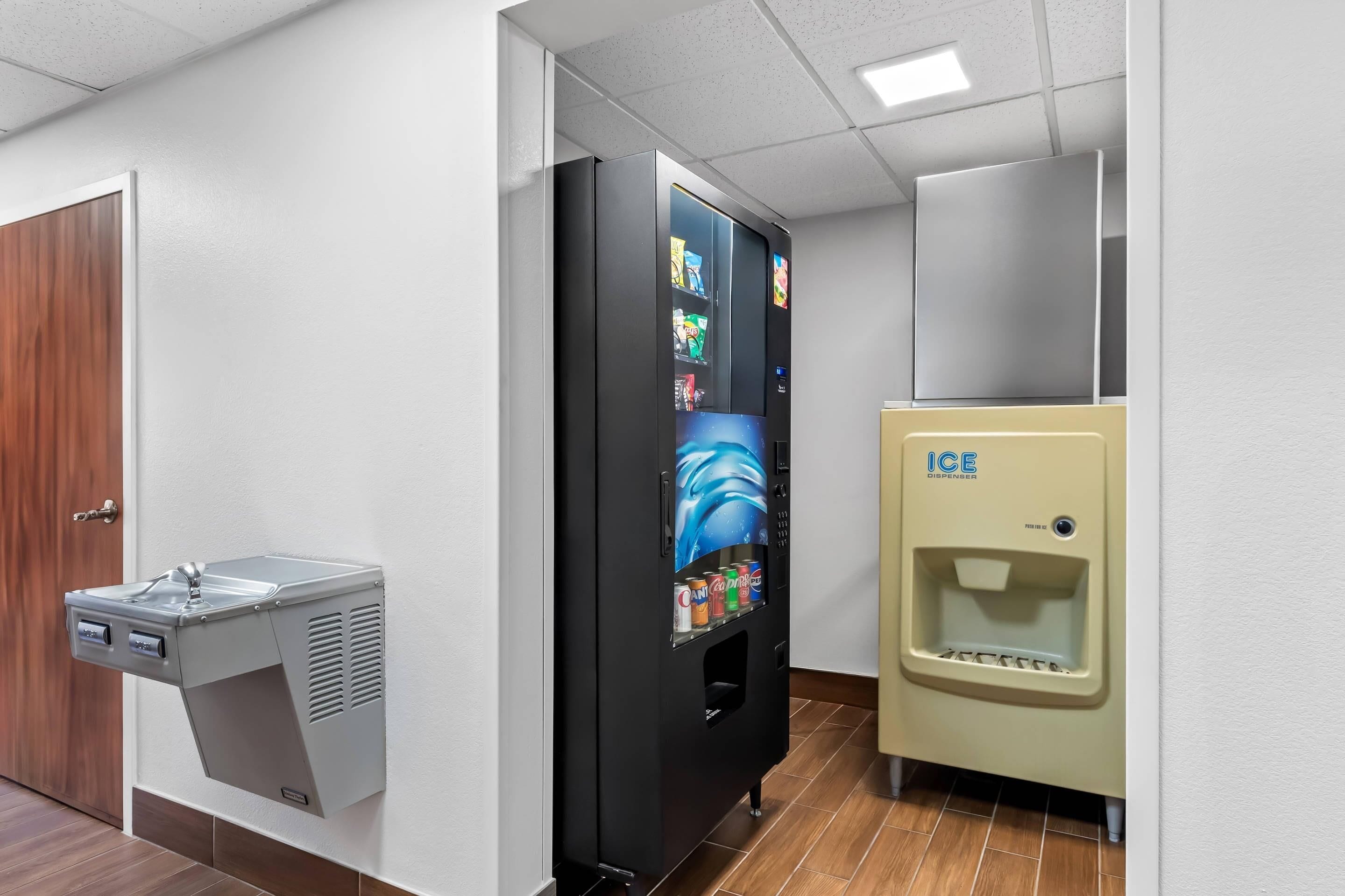 A restroom with a vending machine, a water dispenser, and a sink.
