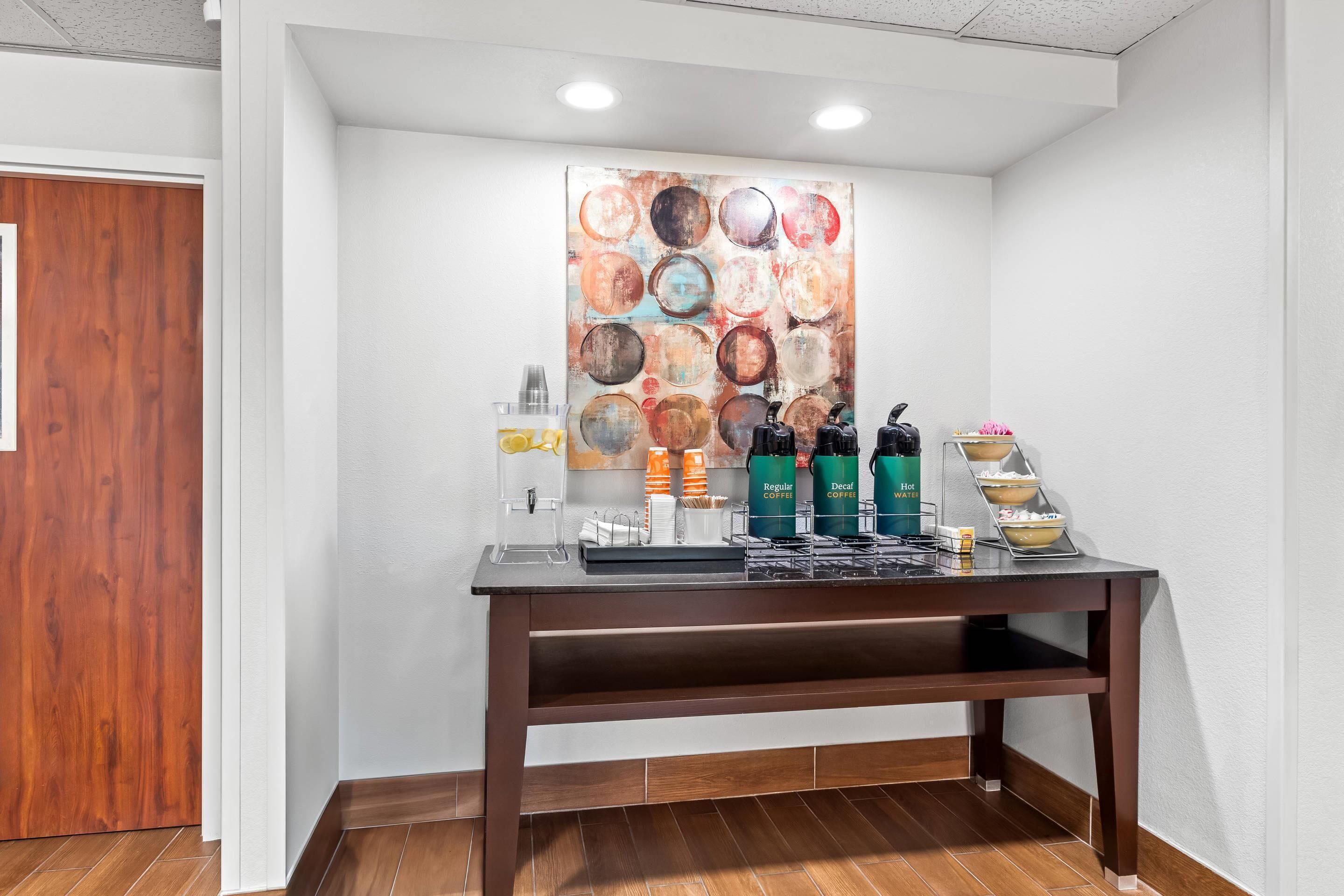 A coffee station with a variety of coffee options and a decorative wall art piece.