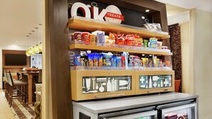 A vending machine with snacks and drinks, a sign for 'OIK TREATS', and a 'VENDING' label.
