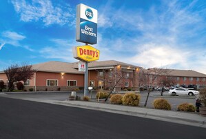 Un hotel Best Western con el letrero de un restaurante Denny's, un estacionamiento y un edificio con múltiples ventanas y fachada de ladrillo.