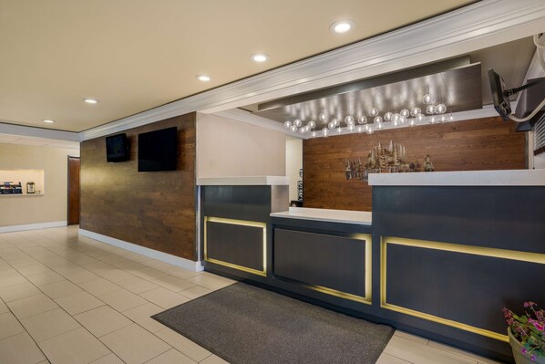 A modern reception area with a wooden accent wall, a flat-screen TV, and a decorative Christmas tree display.