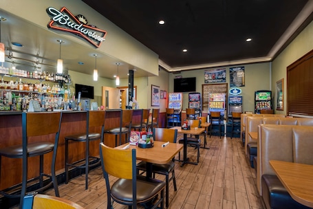 A restaurant interior with booths, tables, a bar area, and arcade games.