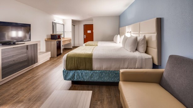 A modern hotel room with a bed, a TV, a desk, and a sofa. - Best Western Sandy Inn (Sandy)