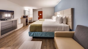 A modern hotel room with a bed, a TV, a desk, and a sofa.