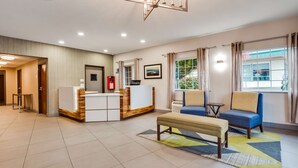 A hotel lobby with a reception desk, seating area, and a view of the outdoors. - Best Western Sandy Inn (Sandy)