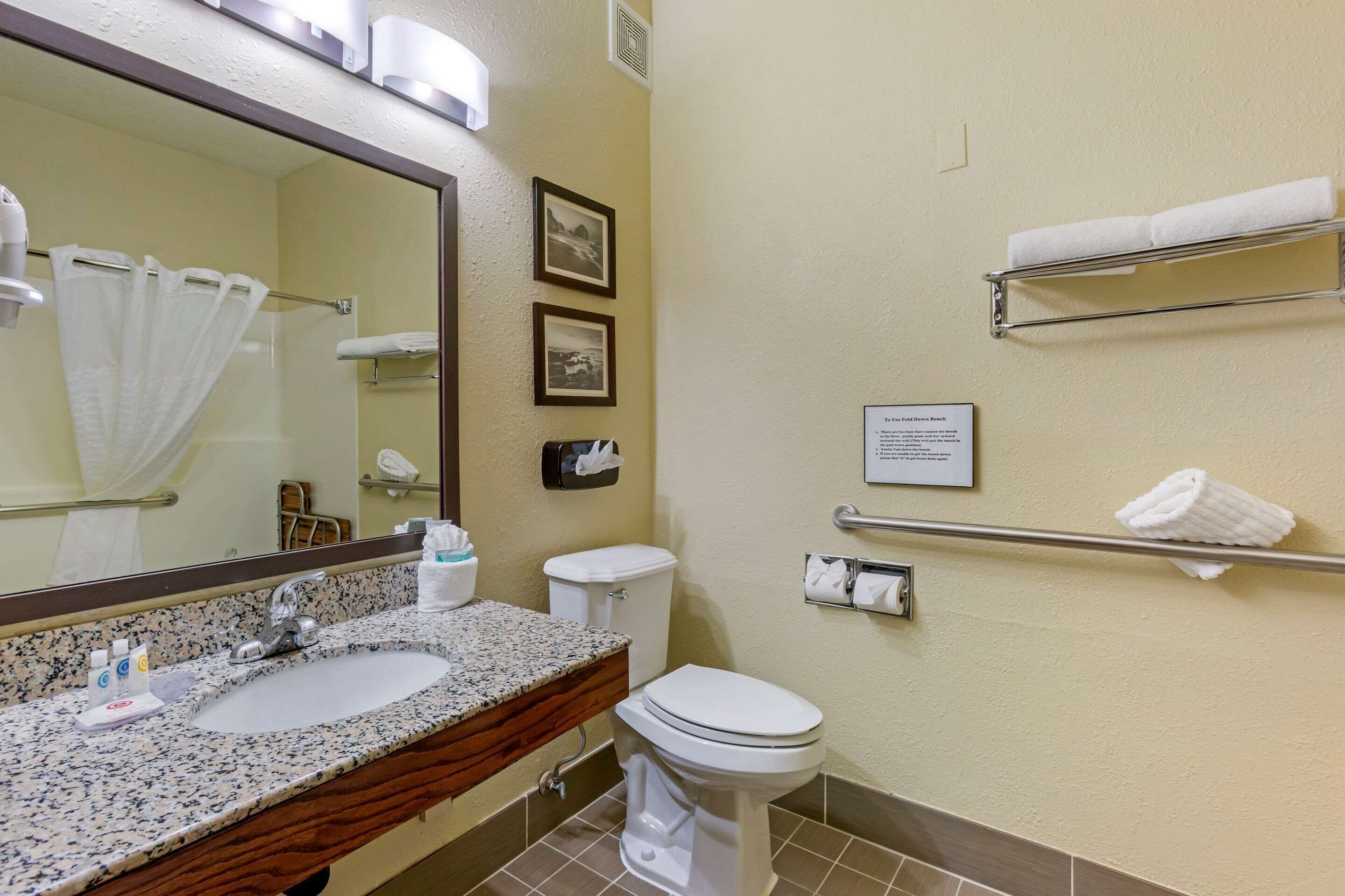 A bathroom with a sink, toilet, and towel rack.