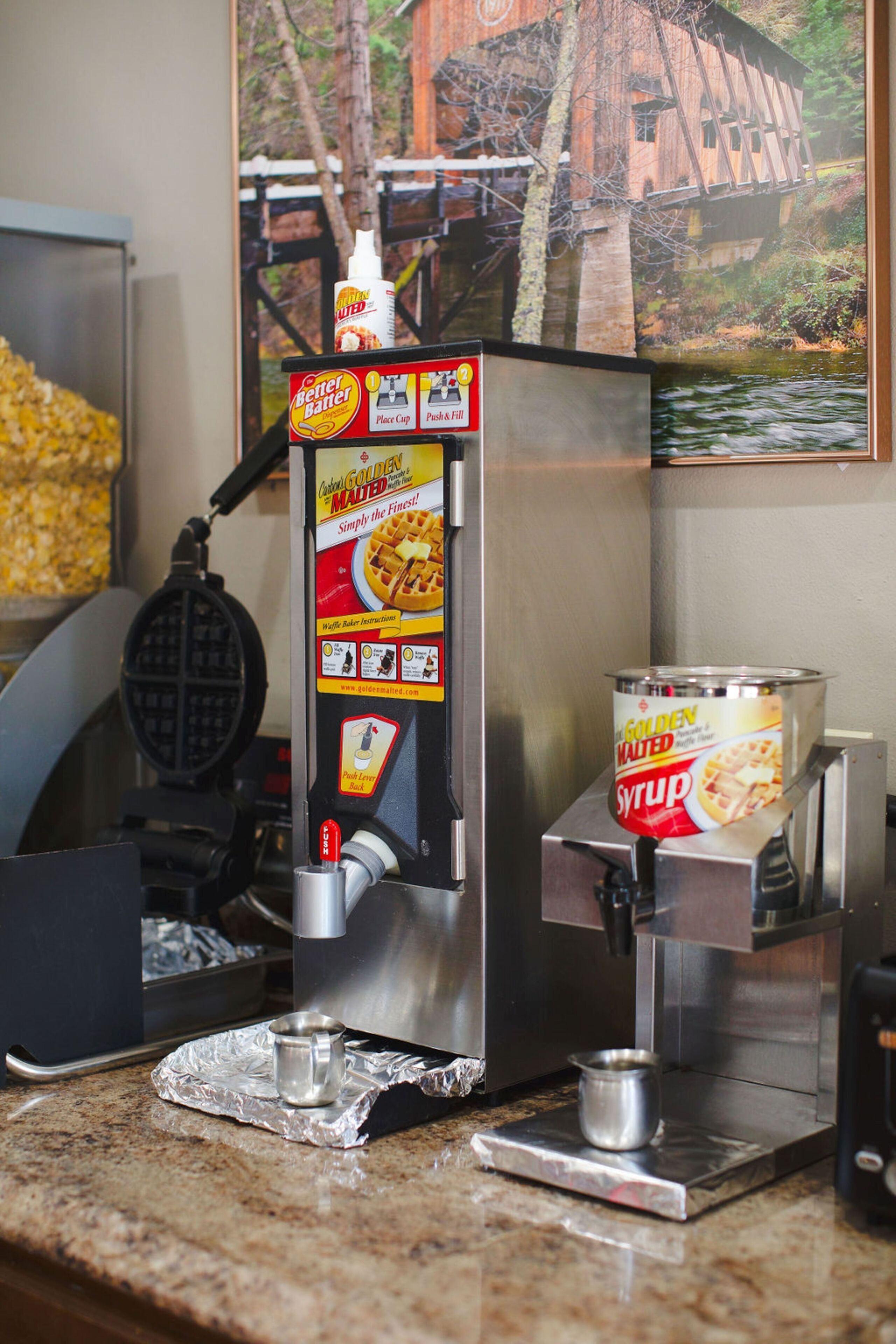 A waffle maker with a syrup dispenser and a waffle iron.