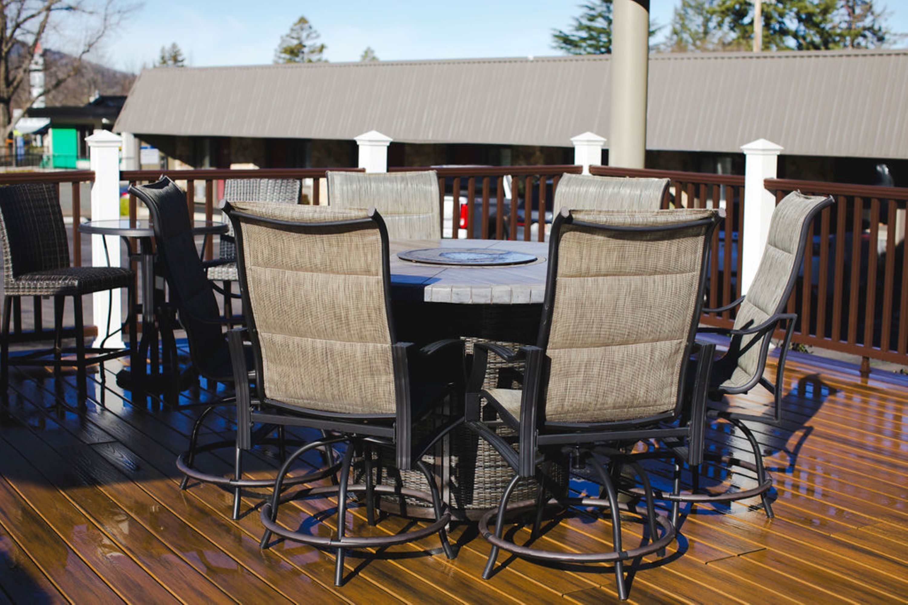 A wooden deck with a round table and four chairs.