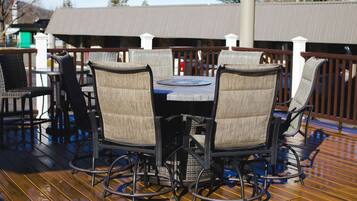 A wooden deck with a round table and four chairs.