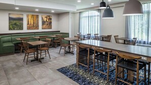 A restaurant with a long counter, booths, and a green seating area. - Fairfield Inn & Suites by Marriott Butler (Butler)