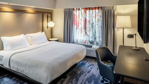 A hotel room with a large bed, a desk, a chair, a TV, and a window with curtains. - Fairfield Inn & Suites by Marriott Butler (Butler)