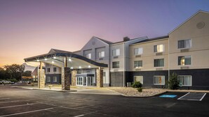 A multi-story hotel with a covered entrance, a parking lot, and a landscaped area with a small garden. - Fairfield Inn & Suites by Marriott Butler (Butler)
