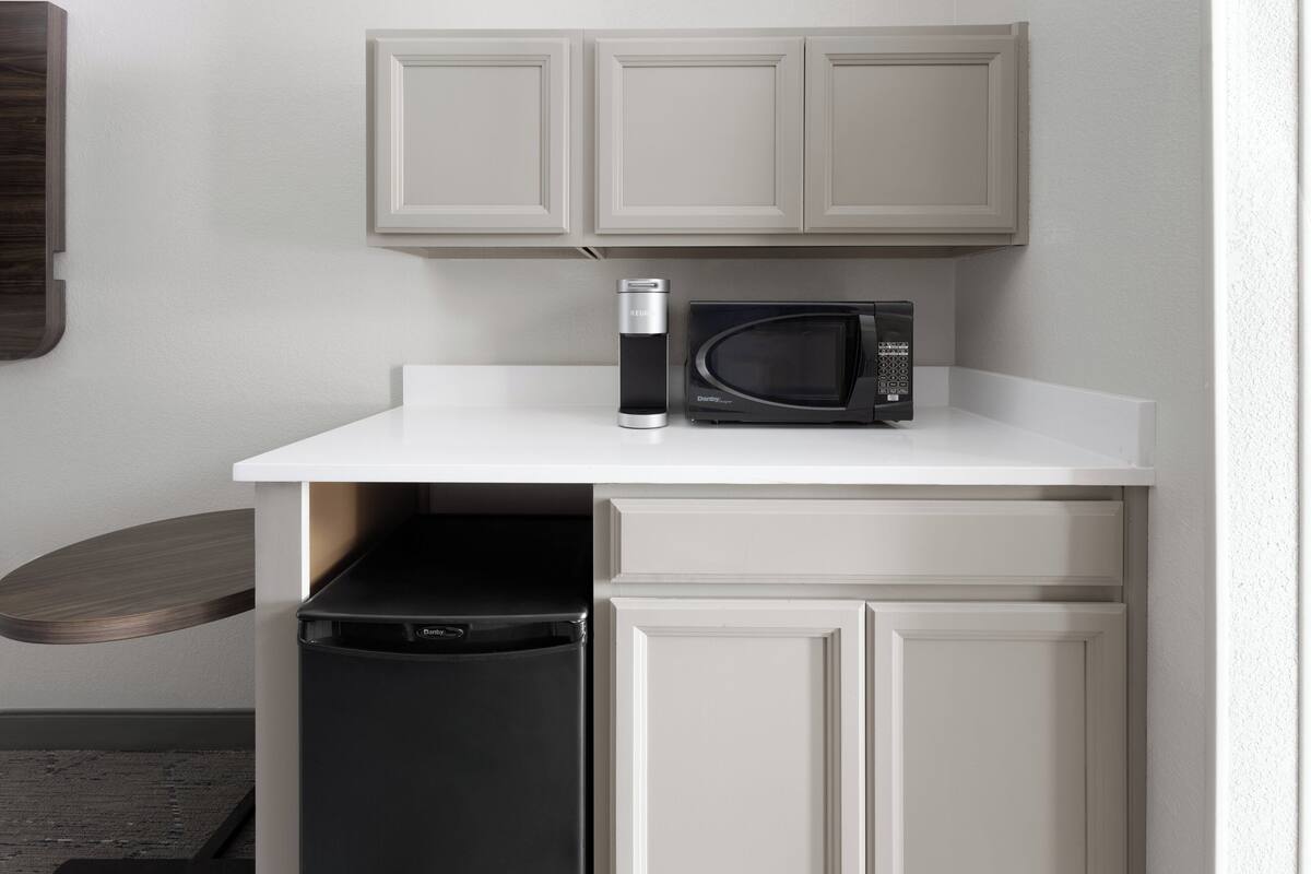 A compact kitchen with a microwave, a coffee maker, and a dishwasher.
