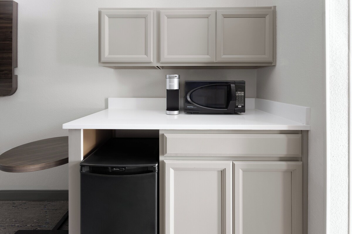 A compact kitchen with a microwave, a coffee maker, and a dishwasher.