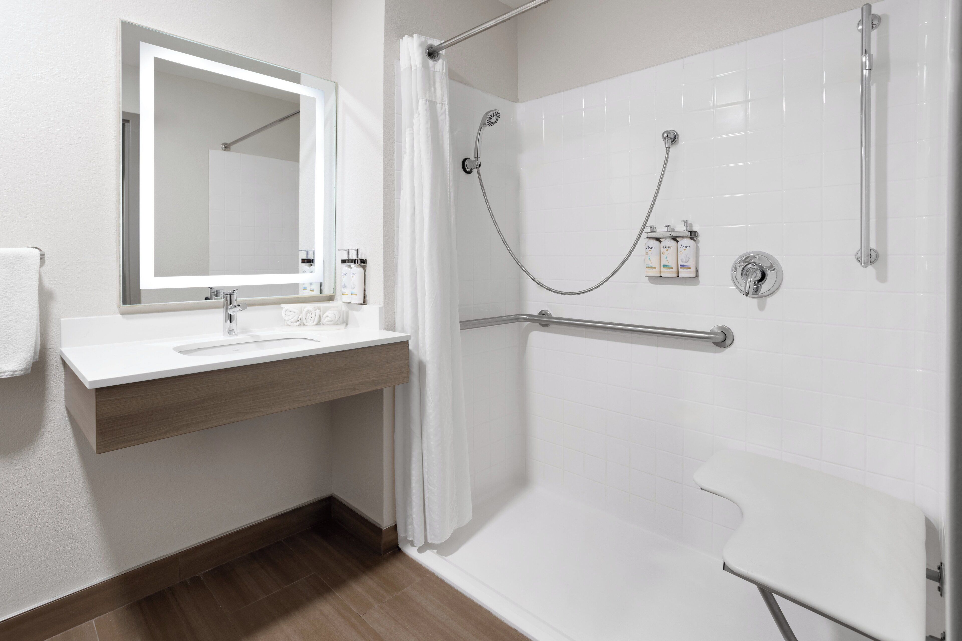 A modern bathroom with a shower, a sink with a mirror, and toiletries.