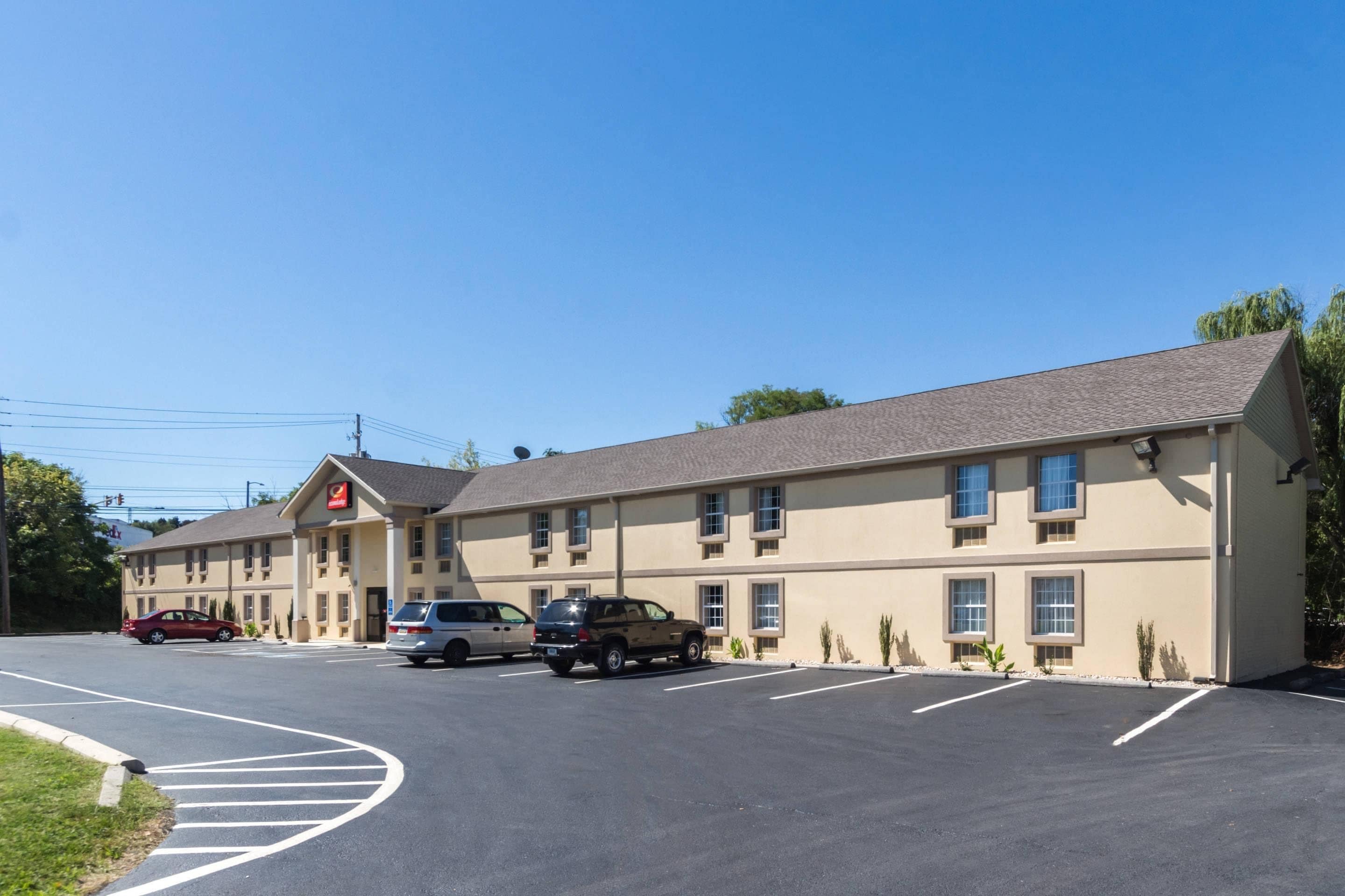 Un motel con varias plazas de aparcamiento y un edificio de techo plano.
